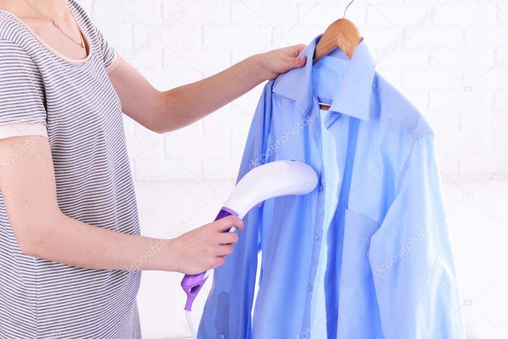 Women steaming shirt in room