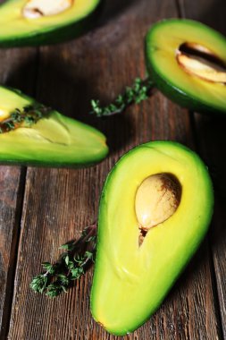 Ahşap arka plan üzerinde avokado ot ile dilimlenmiş