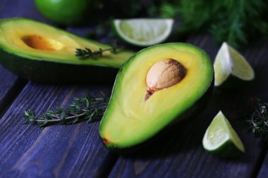 Avokado kireç ve bitki ile ahşap masa, closeup dilimlenmiş