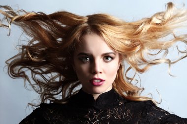 Hafif mavi zemin üzerine siyah elbiseli güzel genç kadın portresi