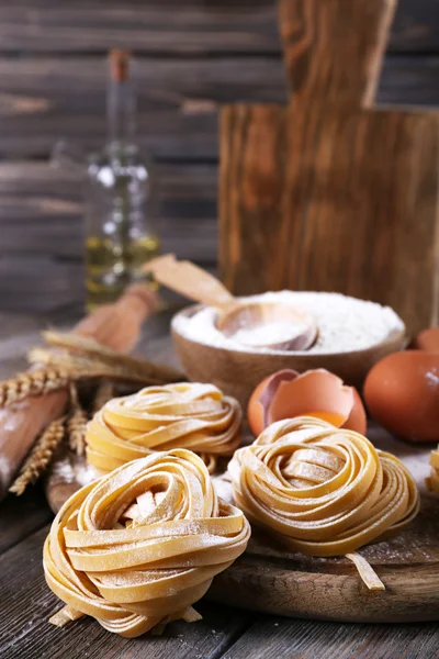 Pasta casera cruda e ingredientes para pasta sobre fondo de madera —  Fotos de Stock