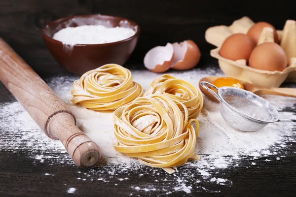 Pasta casera cruda e ingredientes para pasta sobre fondo de madera —  Fotos de Stock