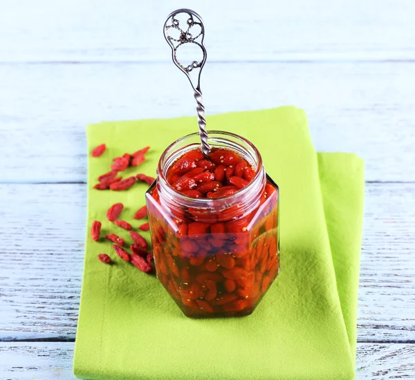 Tarro de mermelada de bayas de goji en servilleta sobre fondo de madera — Foto de Stock