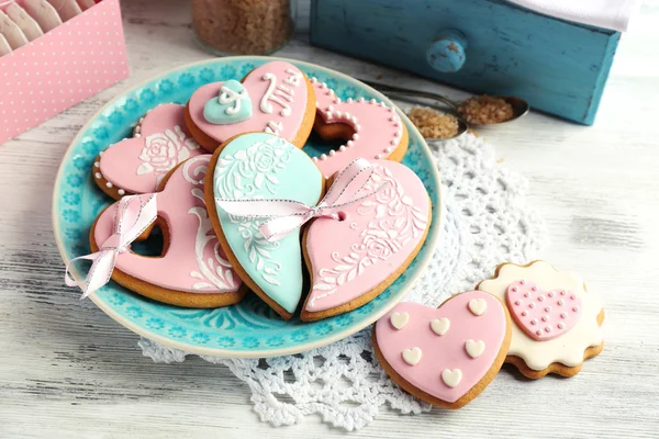 Cookies em forma de coração para dia dos namorados na placa, na cor de fundo de madeira — Fotografia de Stock