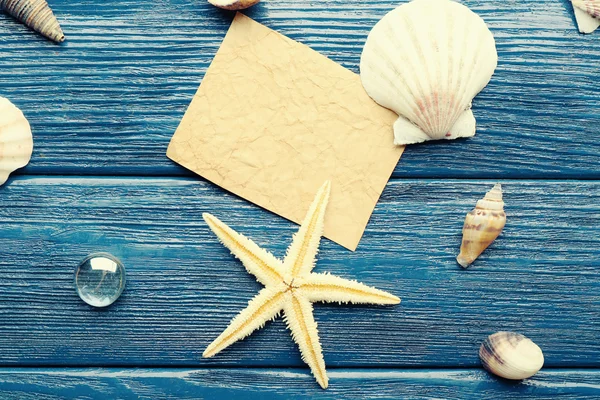 Card blank with sea star and shells on wooden background — Stock Photo, Image