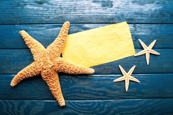 Tarjeta en blanco con estrellas de mar sobre fondo de madera — Foto de Stock