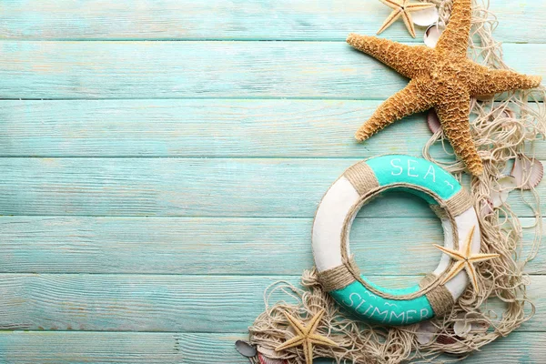 Prachtige zee compositie bij reddingsboei en schelpen op houten achtergrond — Stockfoto