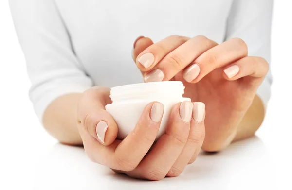 Mãos femininas segurando frasco de creme isolado no branco — Fotografia de Stock