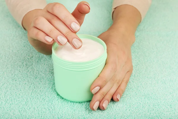 Female hands with jar of cream on fabric background — Stock Photo, Image