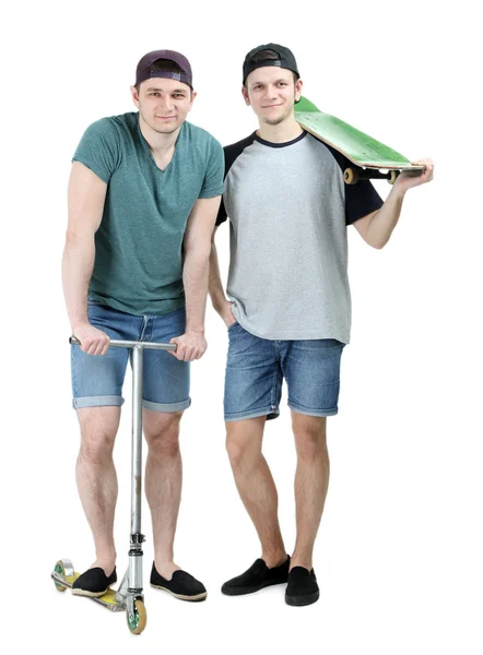 Twee knappe jonge mannen met skate en scooter geïsoleerd op wit — Stockfoto