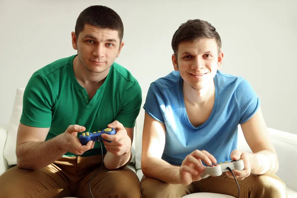 Dois jovens bonitos jogando videogames no quarto — Fotografia de Stock