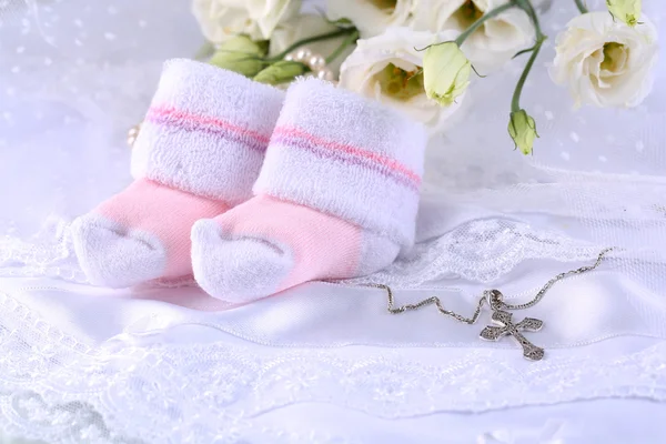 Baby skor, blommor och korset för dop — Stockfoto