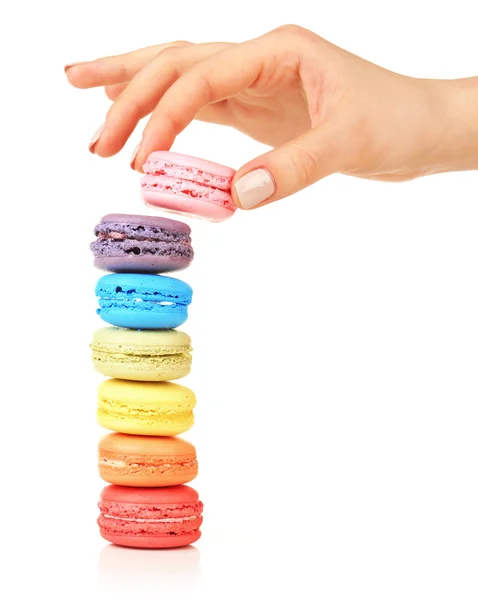 Macaroons coloridos saborosos e mão feminina isolada em branco — Fotografia de Stock