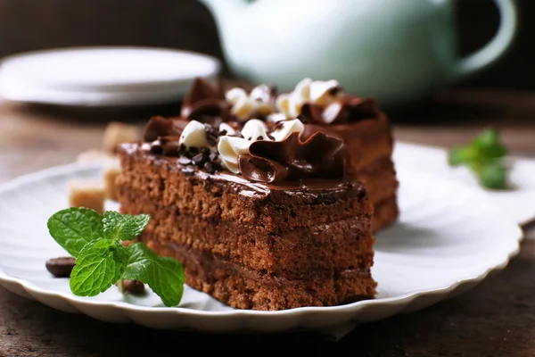 Ahşap masa arka plan üzerine nane ile çikolatalı kek lezzetli parça — Stok fotoğraf