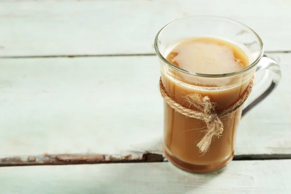 Cangkir kaca coklat pada latar belakang papan kayu warna — Stok Foto