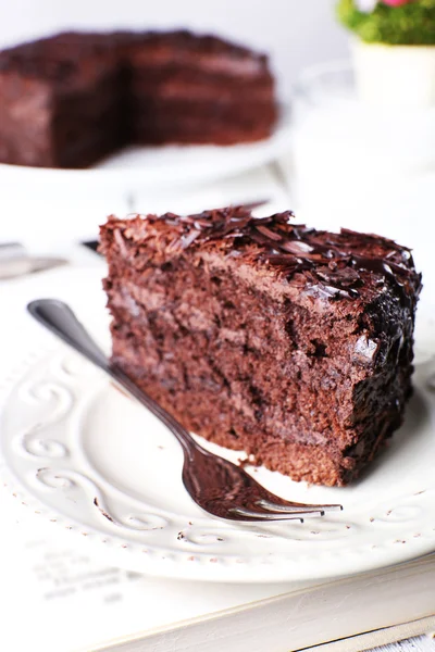 木製テーブル、クローズ アップの上皿で美味しいチョコレート ケーキをスライス — ストック写真