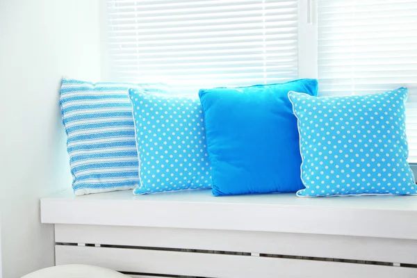 Colorful pillows on windowsill — Stock Photo, Image