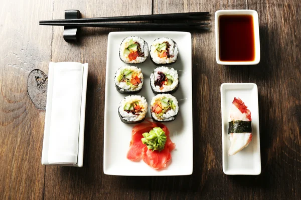 Rollos de sushi vegetariano en plato, sobre fondo de madera —  Fotos de Stock