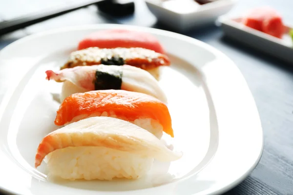 Sushi auf Teller auf Holztischhintergrund — Stockfoto