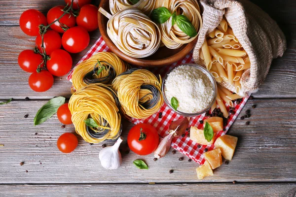 Pasta con tomates cherry y otros ingredientes sobre fondo de mesa de madera —  Fotos de Stock
