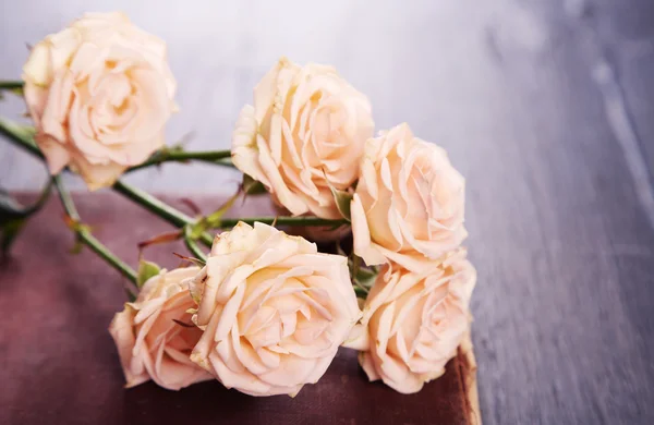 Rosas con libro vintage sobre fondo de mesa de madera — Foto de Stock