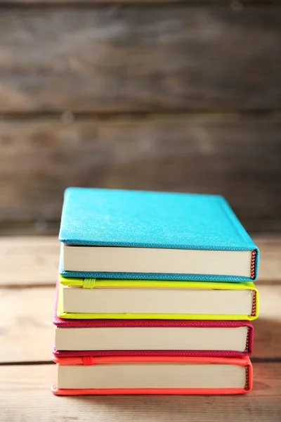 Cadernos coloridos na velha mesa de madeira — Fotografia de Stock