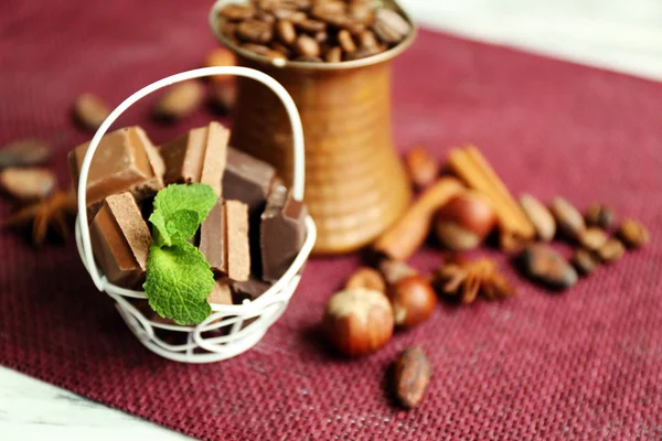 Natura morta con set di cioccolato, spezie e noci su tappetino colorato, primo piano — Foto Stock