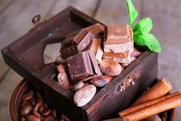 Bodegón con conjunto de chocolate, granos de café y especias en la mesa de madera, primer plano — Foto de Stock