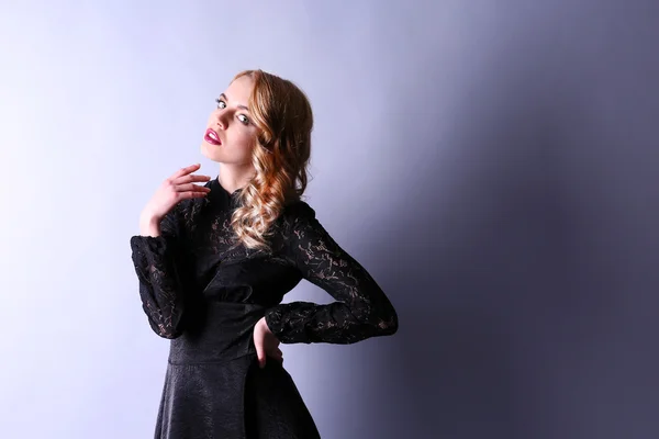 Porträt einer jungen Frau in schwarzem Kleid auf hellem Hintergrund — Stockfoto