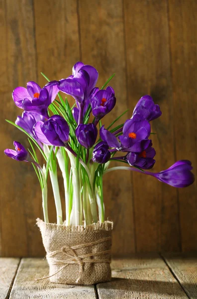 Fleurs de crocus en pot enveloppé sur fond en bois — Photo