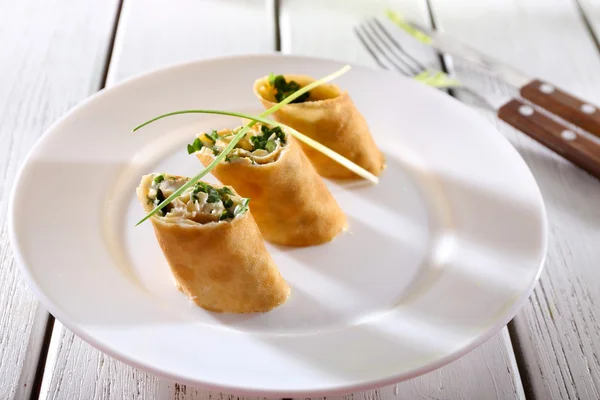 Panqueques con crema, queso y verduras en plato sobre mesa de madera, primer plano — Foto de Stock