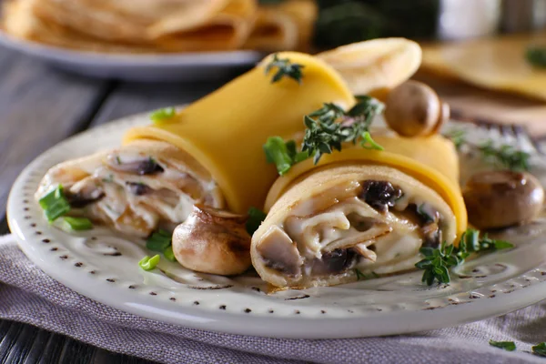 Pfannkuchen mit cremigen Pilzen im Teller auf Holztisch, Nahaufnahme — Stockfoto