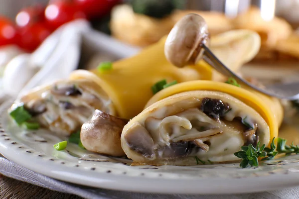 Pfannkuchen mit cremigen Pilzen im Teller auf Holztisch, Nahaufnahme — Stockfoto