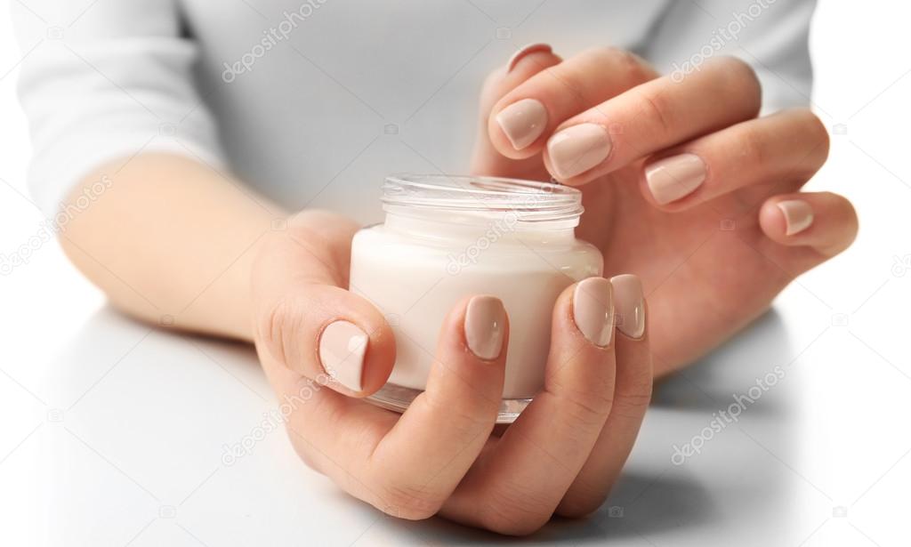 Female hands holding jar of cream isolated on white