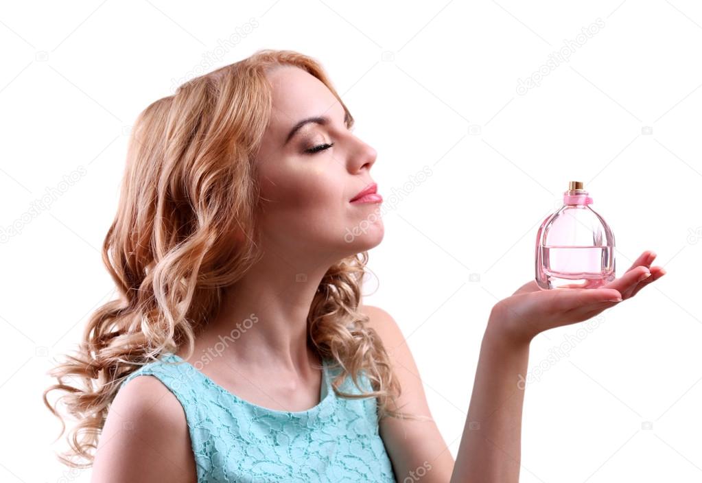 Beautiful young woman with perfume bottle isolated on white