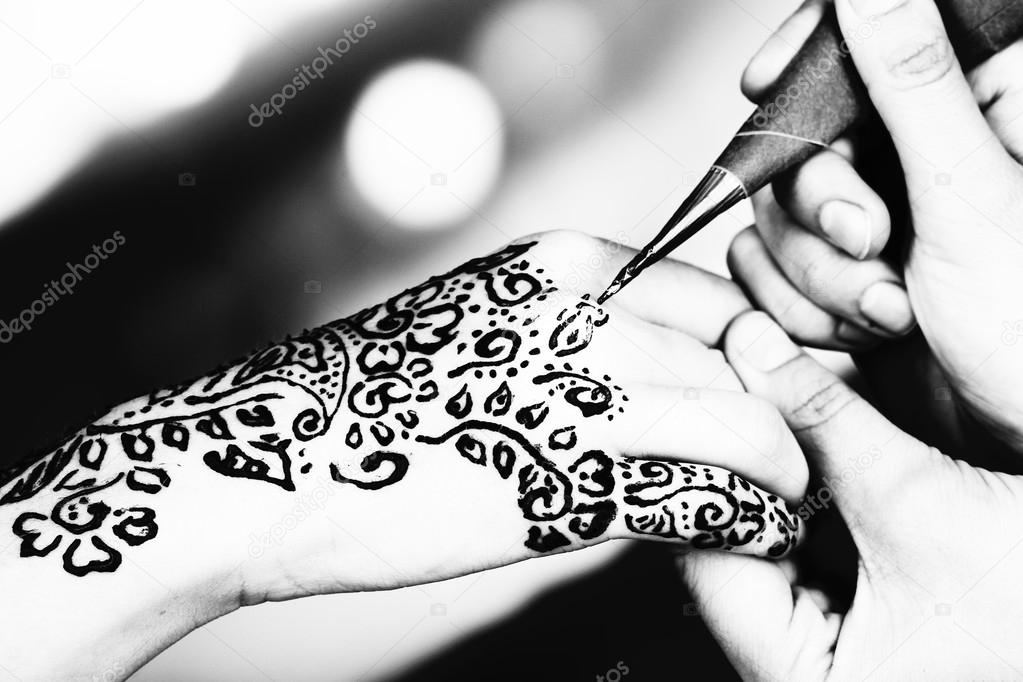 Process of applying Mehndi on female hand, close up