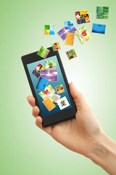 Touch screen mobile phone with streaming images on green background — Stock Photo, Image