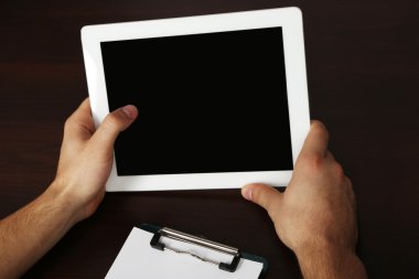 Tablet Pc kullanma ahşap masa arka plan üzerinde eller