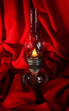 Gaz lambası kırmızı kumaş arka plan üzerinde