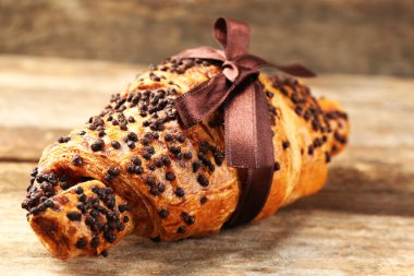 Taze ve lezzetli kruvasan ahşap arka plan üzerinde çikolata ile