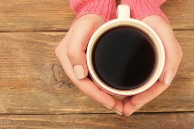 kahve ahşap arka plan üzerinde tutan eller
