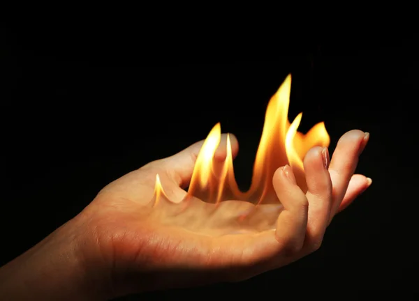 Hand mit Feuer isoliert auf schwarz — Stockfoto