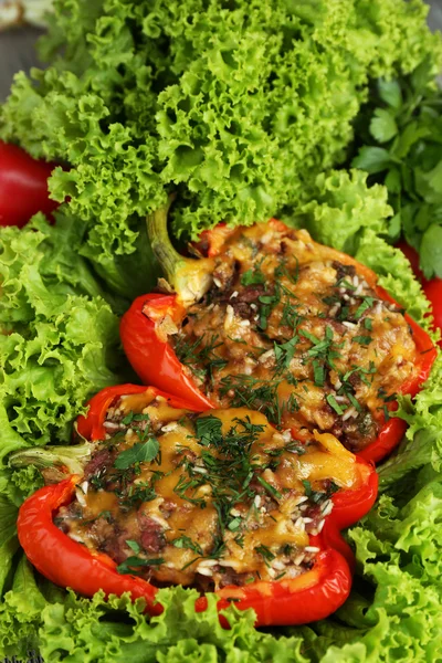 Los pimientos rojos rellenos con la verdura sobre la lechuga se acercan —  Fotos de Stock