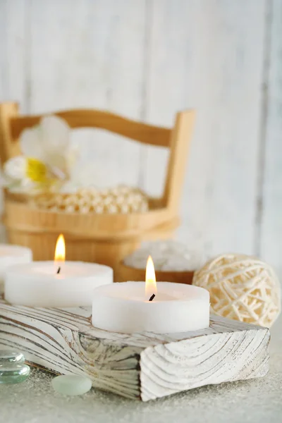 Candles and bucket with spa treatment on wooden background — Stock Photo, Image