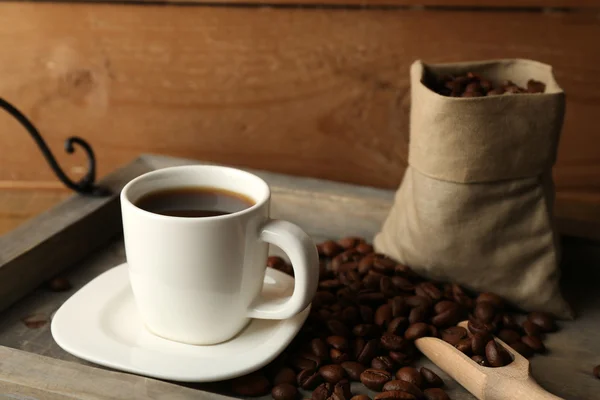 Xícara de café com feijão na bandeja e fundo de madeira rústica — Fotografia de Stock