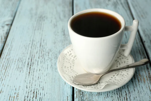 Cup of coffee with spoon on color rustic wooden background — Stock Photo, Image