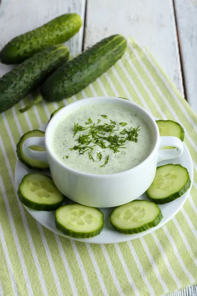 Cucumber soup in bowl on color wooden table background — Stock Photo, Image