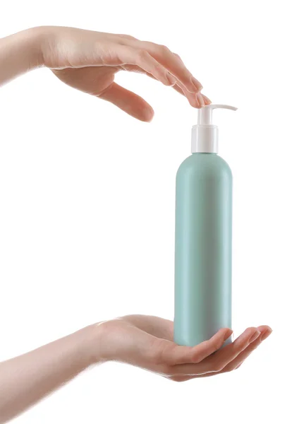 Kvinnliga händer med kosmetika flaska isolerad på vit — Stockfoto