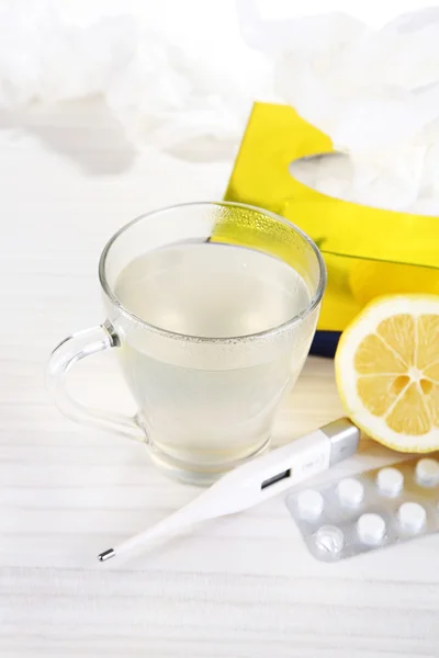 Chá quente para resfriados, pílulas e lenços na mesa close-up — Fotografia de Stock