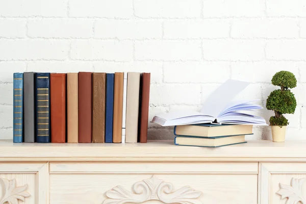 Books on shelf on wall background — Stock Photo, Image